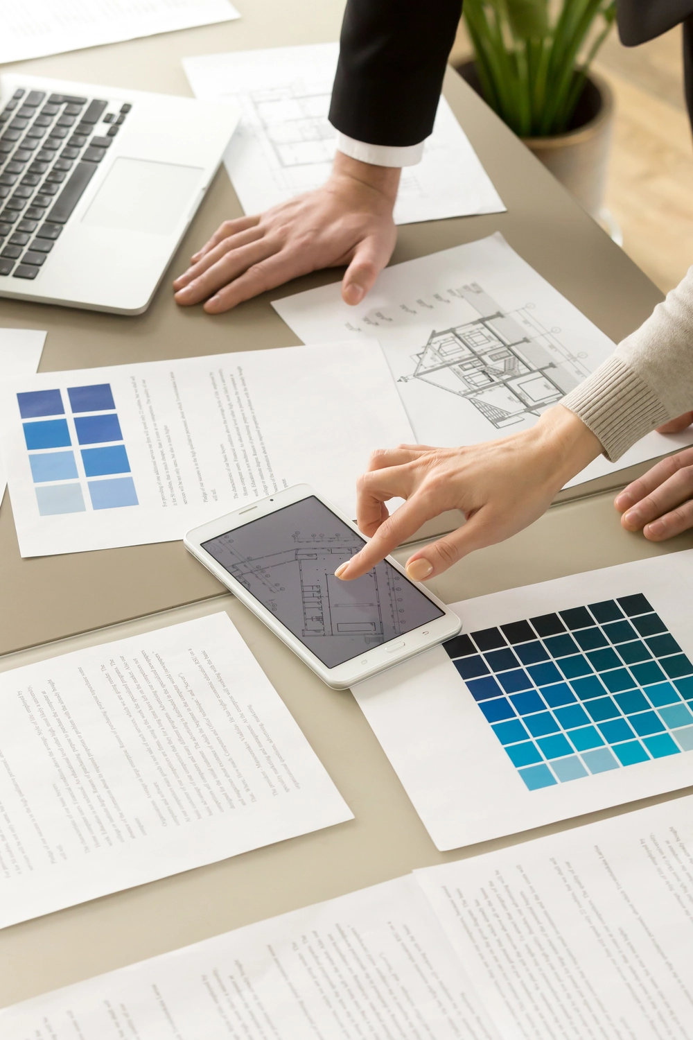 Slooyer GmbH – Gebäudeenergieberater – Dieses Bild zeigt eine Baustelle, auf der Fachleute Baupläne prüfen, um die Genauigkeit und Sicherheit des Projekts sicherzustellen.